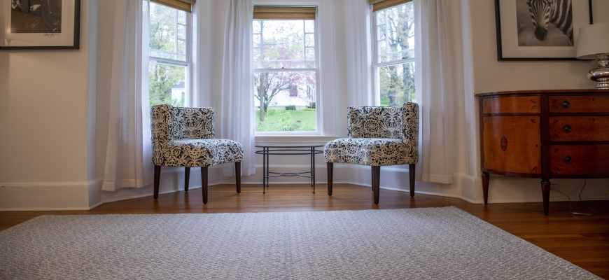 Herdwick wool thick woven rug in a living room with printed chairs by windows