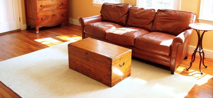 Nottingham 6x9 Thick Woven Wool rug in a living room with a wooden chest and leather couch, alternate angle
