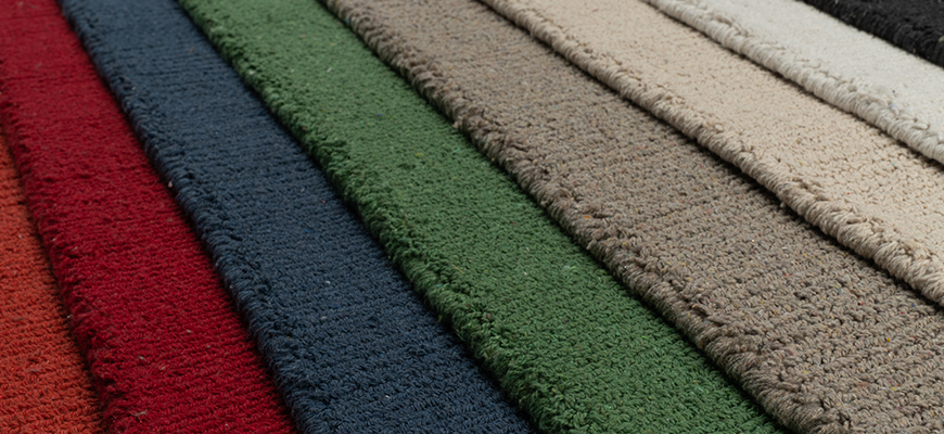 Overlapping flat stacked edges of several Solid Eco Cotton Loom-hooked rugs